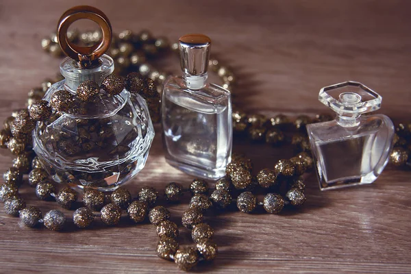 Perfume and gold beads — Stock Photo, Image