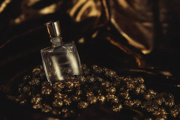 Perfume and gold beads — Stock Photo, Image