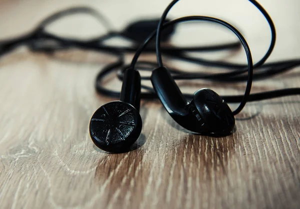 Auriculares negros en fondo de madera —  Fotos de Stock