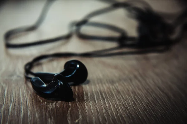 Auriculares negros en mesa de madera —  Fotos de Stock