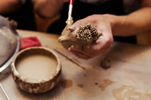 Handen werken en afwerking van beeldhouwkunst met klei op houten tafel — Stockfoto