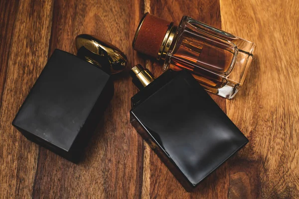 Dos botellas negras de perfume en fondo de madera — Foto de Stock