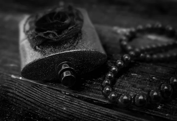 Černý parfém s perlami v dřevěné pozadí — Stock fotografie