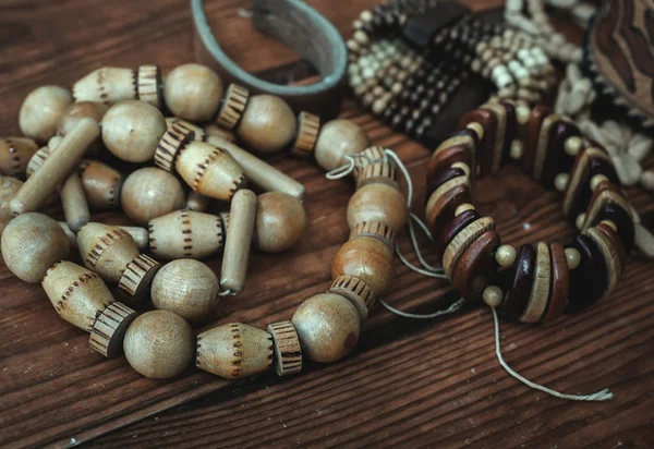 Various bracelets and beads over wooden background close up — Stock Photo, Image