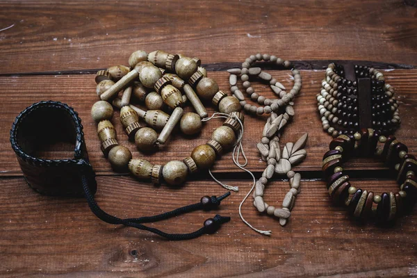 Various bracelets and beads over wooden background close up — Stock Photo, Image