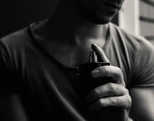 Perfume masculino. homem segurando perfume. foto branca escura — Fotografia de Stock