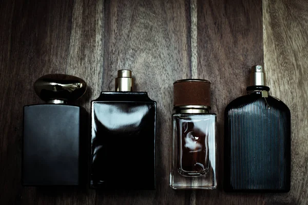 Различные духи бутылки на деревянном фоне — стоковое фото