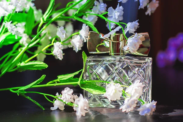 Garrafa feminina de perfume com flores brancas — Fotografia de Stock