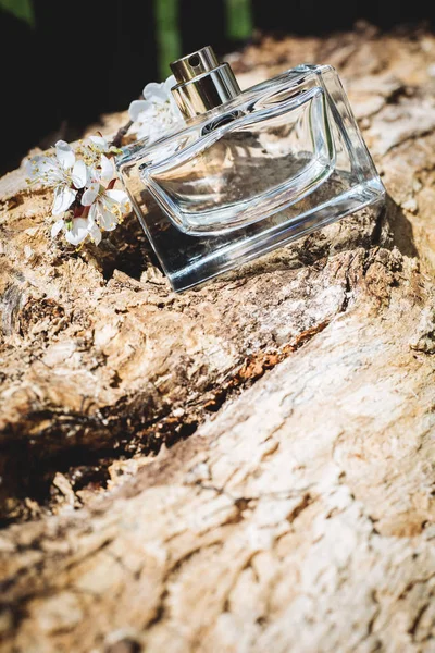 Butelek perfum i kwiatów na podłoże drewniane — Zdjęcie stockowe