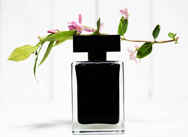 Perfume bottle with pink flower — Stock Photo, Image