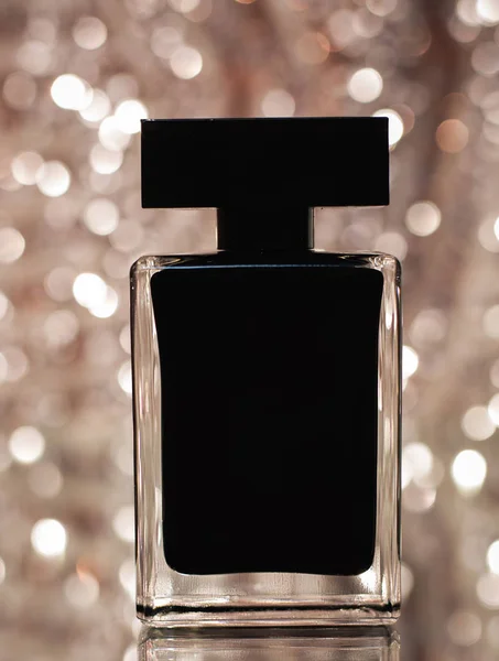 Fekete üveg parfüm pink bokeh háttér felett — Stock Fotó