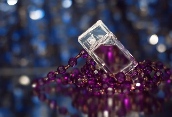 Perfume femenino con perlas moradas —  Fotos de Stock