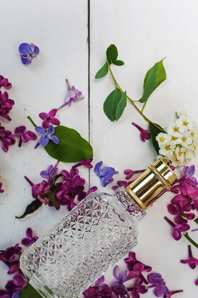 Parfümös üveg, lila virágok — Stock Fotó