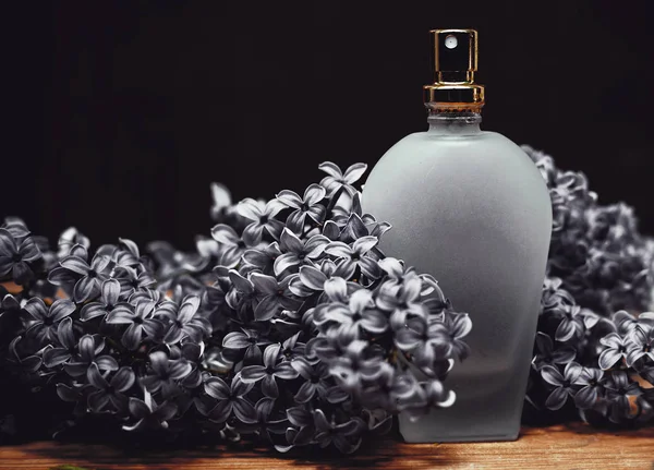 Бутылка духов с цветами сирени — стоковое фото