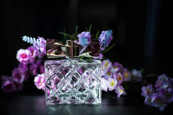 Parfymflaska i rosa blomma — Stockfoto