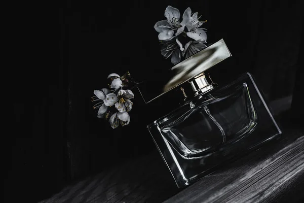 Parfum féminin avec fleurs en fond de bois — Photo