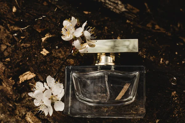 Botella de perfume con flores sobre fondo de madera — Foto de Stock