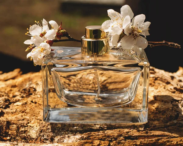 香水瓶与木制背景上的花朵 — 图库照片