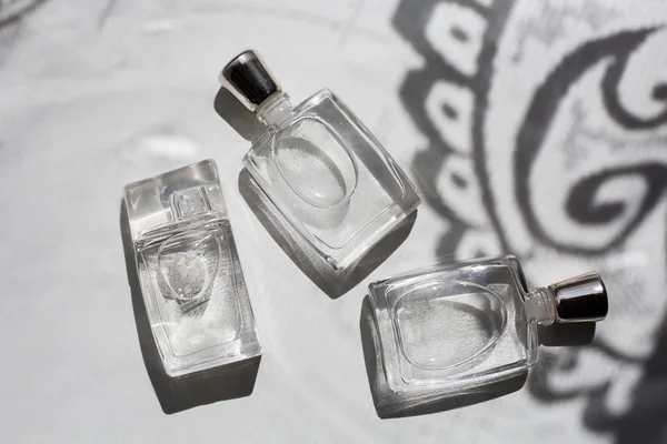 Három kis üveg parfüm a szürke háttér — Stock Fotó