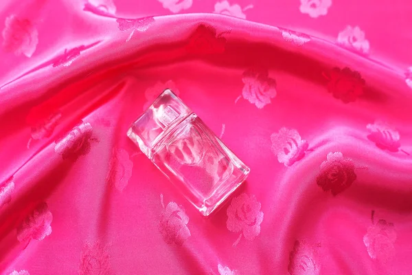 Küçük şişe parfüm pembe bir arka plan üzerinde 