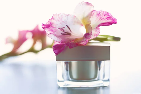 Body cream with pink flowers over white — Stock Photo, Image
