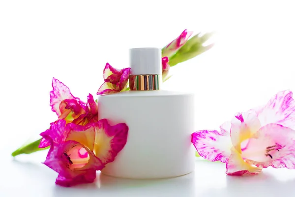 Parfym med rosa blommor över vita — Stockfoto