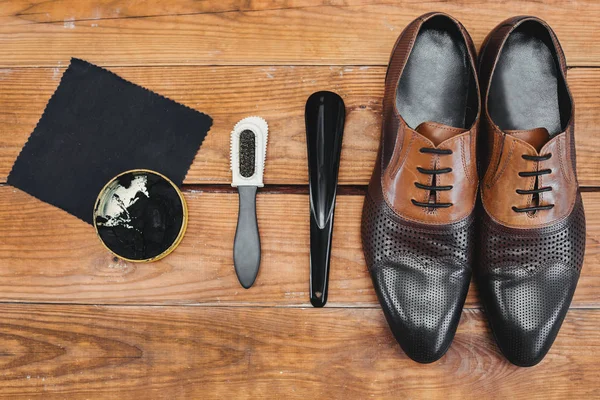 Schuhpflege. Schuhwachs und Bürsten auf Holzoberfläche. — Stockfoto
