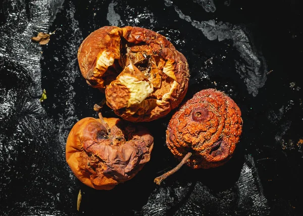 Rotten apples on a black background — Stock Photo, Image