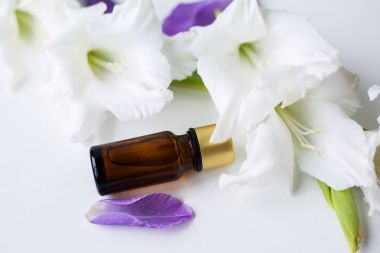 esans çiçeklerle çevrili şişe