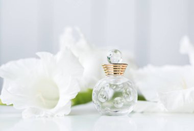 Küçük şişe parfüm üzerinde beyaz çiçekli