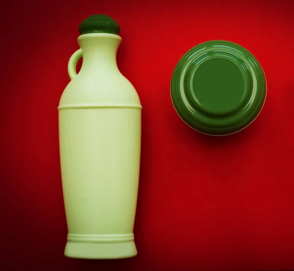 Lotion et crème pour le corps en bouteilles vertes sur fond rouge — Photo