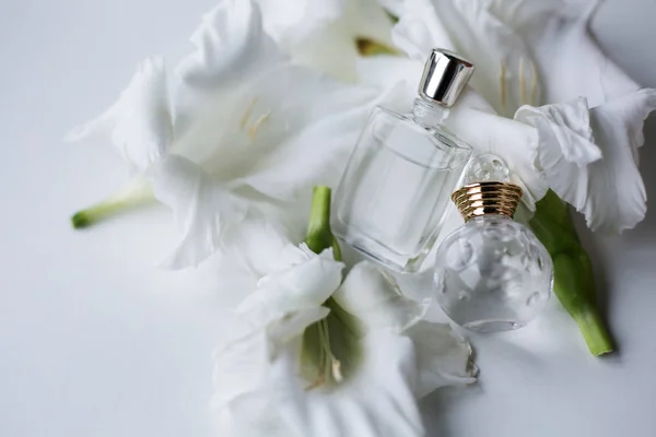 Δύο μπουκάλια αρώματος με λευκά λουλούδια — Φωτογραφία Αρχείου