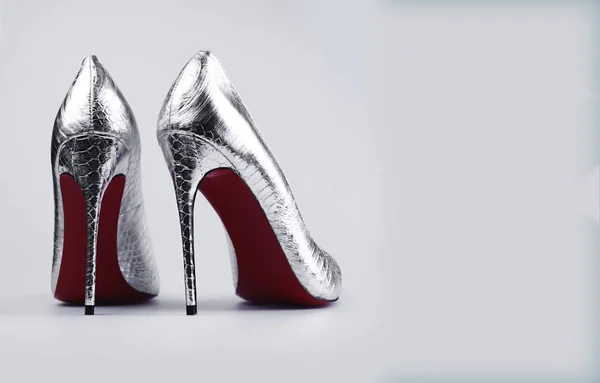 Elegante weibliche silberne Schuhe über grau — Stockfoto