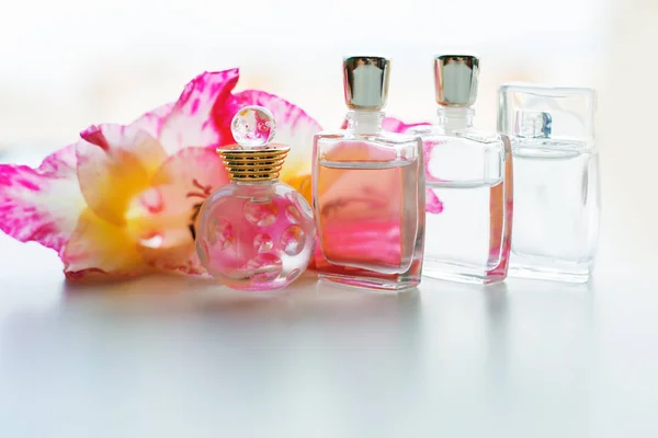 Perfume bottle with flowers on light background. Perfumery, cosm — Stock Photo, Image