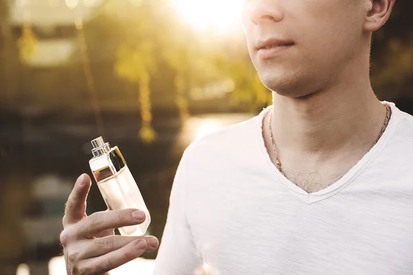 Male perfume. man holding perfume