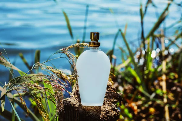 Doğal parfüm şişesi üzerinde mavi bir arka plan bulanık