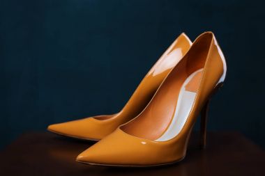 Koyu ahşap yüzey üzerinde sarı kadın ayakkabı. Wom için Ayakkabı Yaz