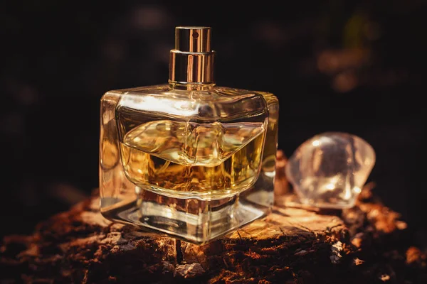 Parfumfles op houten oppervlak tegen zwarte achtergrond — Stockfoto