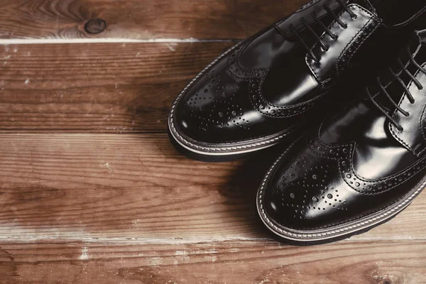 Zapatos negros clásicos en fondo de madera — Foto de Stock