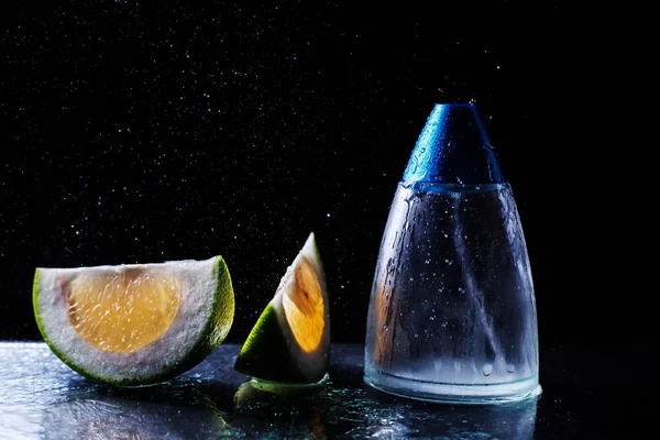 Пляшка сучасних чоловічих парфумів і цитрусових скибочок на темному фоні — стокове фото