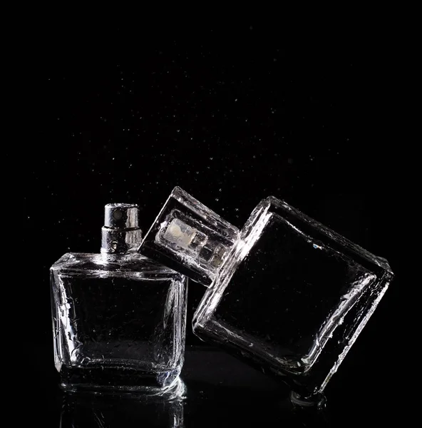 Parfumfles met splash over zwart — Stockfoto