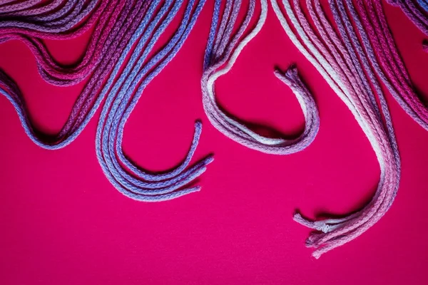 Барвисті швейні нитки на рожевому фоні — стокове фото