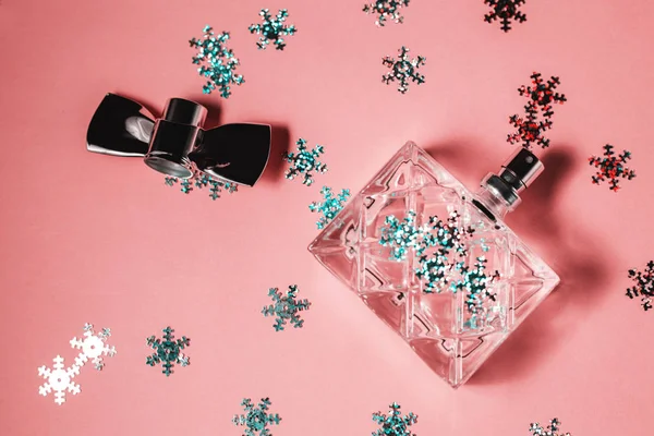 Perfume feminino com decoração cristmass sobre fundo rosa — Fotografia de Stock