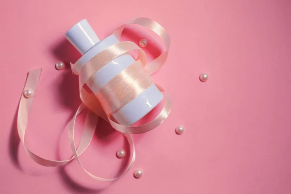 Botella de perfume blanco sobre fondo rosa — Foto de Stock