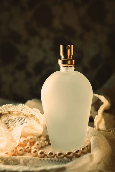 Бутылка духов с белым жемчугом — стоковое фото