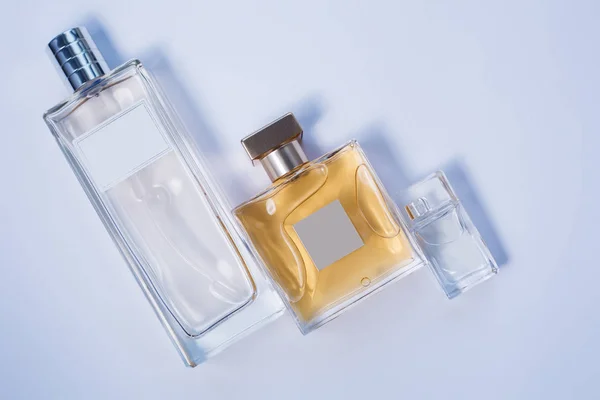 Three bottles of perfumes over grey — Stock Photo, Image