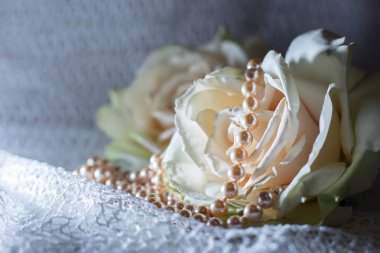 İnci bir kolye ile yumuşak pembe Gül