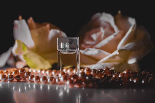 Perfume bottle with flowers and pearls — Stock Photo, Image