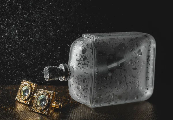 Stylish bottle of wet perfume with cuff — Stock Photo, Image