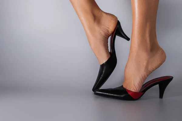 Frauenbeine in schönen Schuhen über grau — Stockfoto